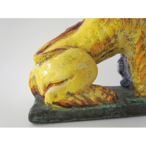 7518 - A 19th Century Italian faience figure of a lion with heraldic crest, 23cm high