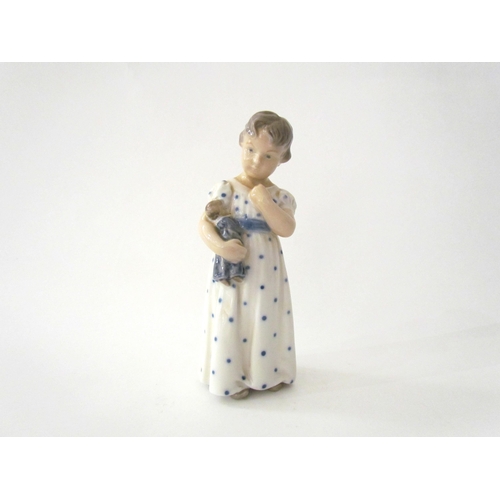 7521 - A Royal Copenhagen figure of child holding a doll, 15cm tall