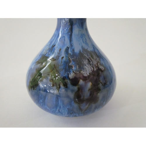 7524 - A Cobridge Stoneware onion shaped vase in mottled blue glaze with bunches of grapes and vine leaf de... 