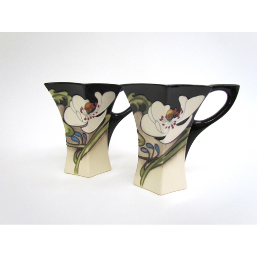 7555 - A pair of Moorcroft Au Lait pattern coffee cups and saucers