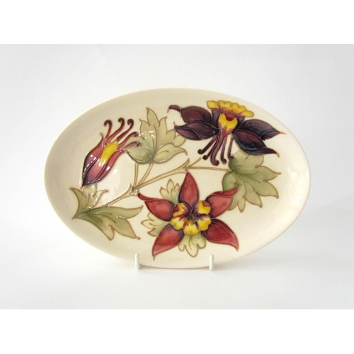 7574 - A Moorcroft Aquilegia pattern oval plate, 23cm x 15.5cm