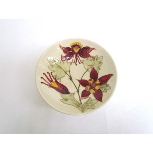 7575 - A Moorcroft Aquilegia pattern shallow bowl on cream ground, 18.5cm diameter