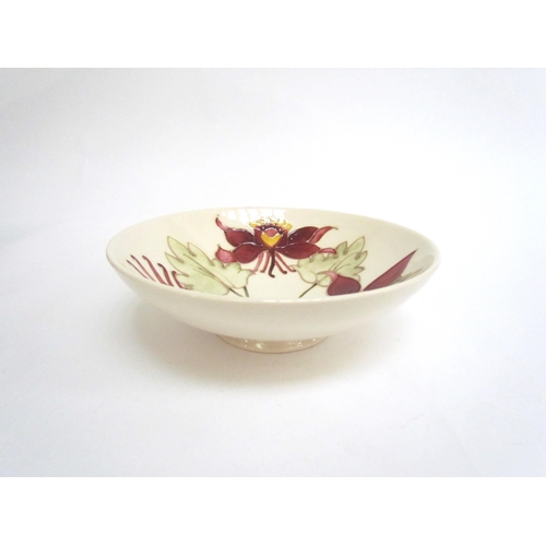 7575 - A Moorcroft Aquilegia pattern shallow bowl on cream ground, 18.5cm diameter