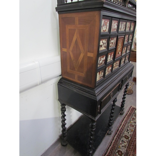 7594 - An 18th Century European cabinet on stand, the spindle rail cornice over an eight drawer and single ... 