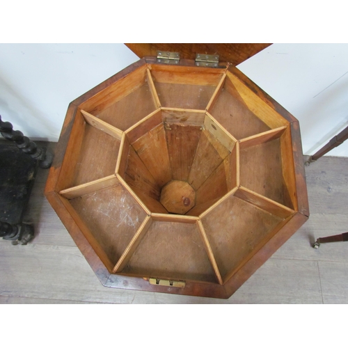 7606 - A reproduction burr walnut sewing table, the octagonal top over a faceted column to a carved tripod ... 