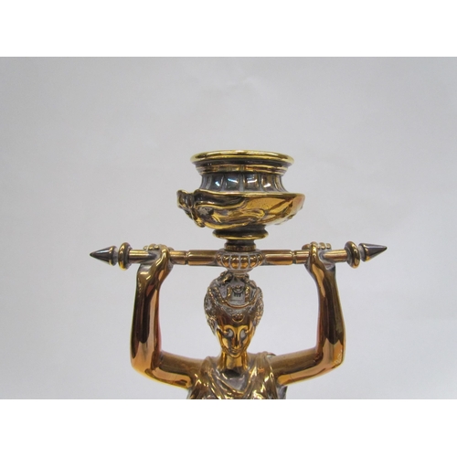 7644 - A pair of brass candlesticks as robe clad females, upon grey marble plinth bases, 30cm high