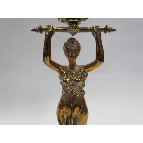 7644 - A pair of brass candlesticks as robe clad females, upon grey marble plinth bases, 30cm high