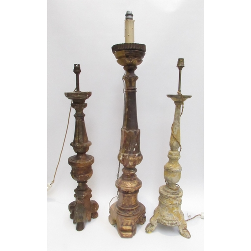 7019 - Three 19th Century carved wood lamp bases in a rustic condition, 94cm, 76cm and 73cm tall