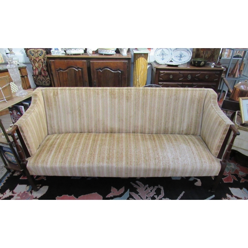 7103 - A late 19th Century square back sofa with turned arms to reeded tapering square legs to castors, uph... 