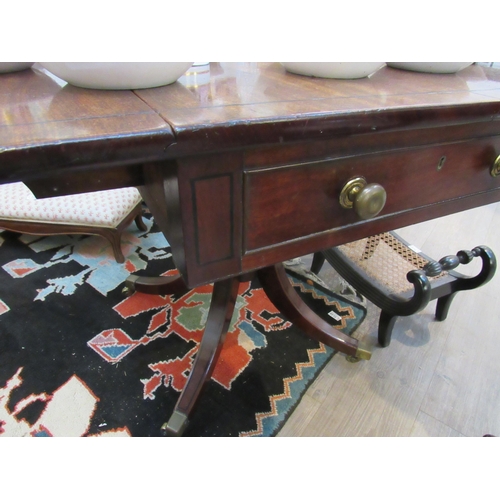 7112 - A Regency mahogany drop flap library centre table with one true drawer, ring turned column to quatre... 