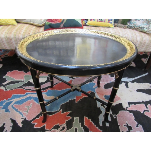 7116 - A Regency papier mache black lacquered oval Gentleman's tray table with gilt border. The tray lifts ... 