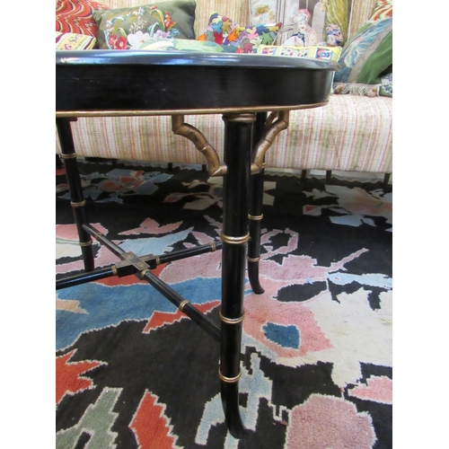 7116 - A Regency papier mache black lacquered oval Gentleman's tray table with gilt border. The tray lifts ... 