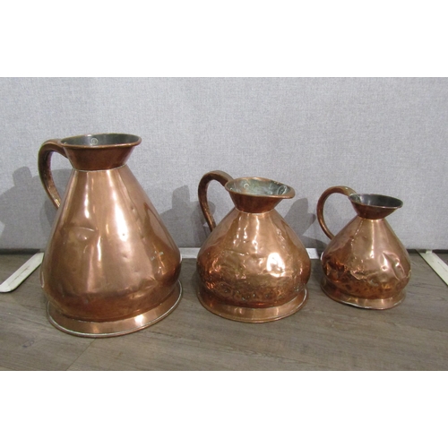 7154 - A Victorian copper four gallon jug, two gallon jug and a one gallon jug (dented), 42cm, 29cm & 26cm ... 