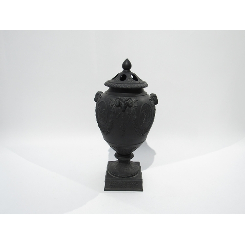 7189 - A Wedgwood black basalt lidded urn with ram's head detail. The lid is damaged and nibble to rim, 32c... 