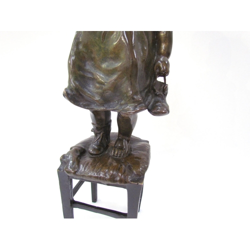 7617 - JUAN CLARA AYATS (1875-1958): A bronze sculpture of young girl standing on a rush seated stool, hold... 