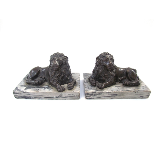 7621 - A pair of bronze sculptures of recumbent lions, on marble bases, each 13.5cm long