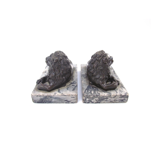 7621 - A pair of bronze sculptures of recumbent lions, on marble bases, each 13.5cm long