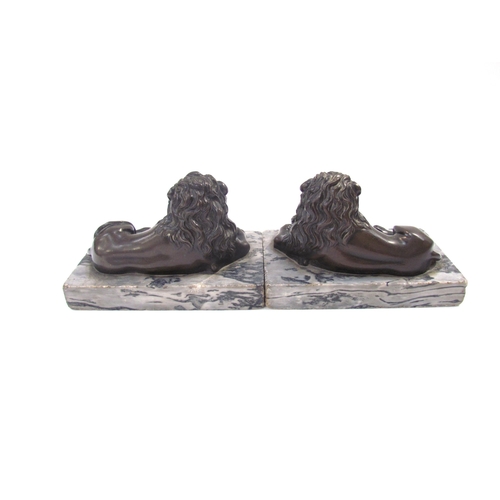 7621 - A pair of bronze sculptures of recumbent lions, on marble bases, each 13.5cm long