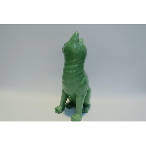 7778 - A Galle style Staffordshire cat, green glazed with glass eyes, standing 33.5cm tall