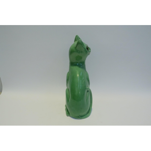 7778 - A Galle style Staffordshire cat, green glazed with glass eyes, standing 33.5cm tall