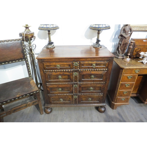 7788 - A 17th Century walnut chest of four long graduating drawers, later added beaded detail, on heavy bun... 