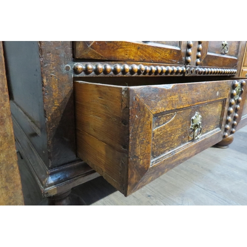 7788 - A 17th Century walnut chest of four long graduating drawers, later added beaded detail, on heavy bun... 