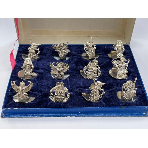 7259 - A set of 12 Sterling silver Thai name place holders, all decorated with deities in fitted Jewels by ... 