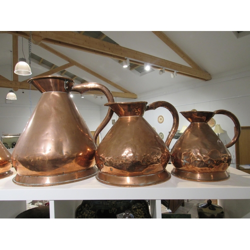 7154 - A Victorian copper four gallon jug, two gallon jug and a one gallon jug (dented), 42cm, 29cm & 26cm ... 