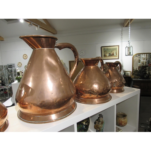 7154 - A Victorian copper four gallon jug, two gallon jug and a one gallon jug (dented), 42cm, 29cm & 26cm ... 