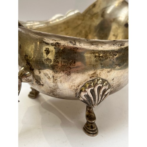 7316 - An Elkington & Co. silver gravy boat, scroll handle, shell and hoof feet, shaped edge, Birmingham 19... 