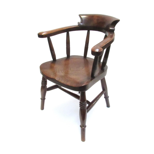 7812 - A late Victorian elm child's Captains armchair the broad arms over ring turned supports and legs joi... 