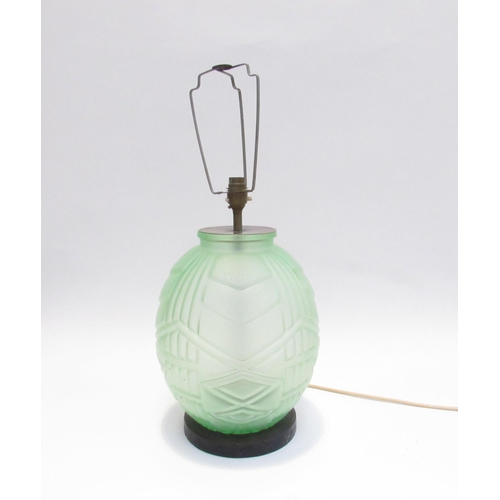 7821 - An Art Deco green glass lamp of bulbous form on carved wood base