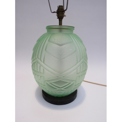 7821 - An Art Deco green glass lamp of bulbous form on carved wood base