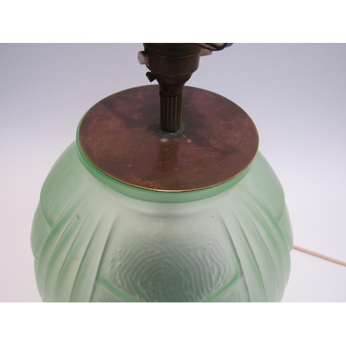 7821 - An Art Deco green glass lamp of bulbous form on carved wood base