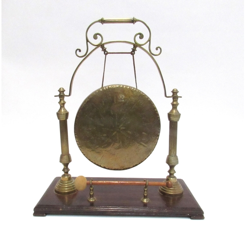 7830 - A Victorian brass dinner gong with striker, overall height 45cm tall