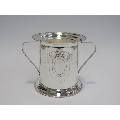 7831A - A silver plated ice bucket with twin handles, ribbon and swag detail, 16cm tall