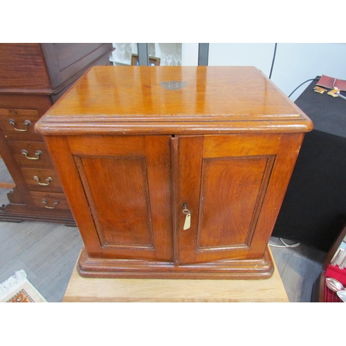 7508 - An early 20th Century honey oak collector’s chest / cutlery canteen, the twin panelled doors opening... 