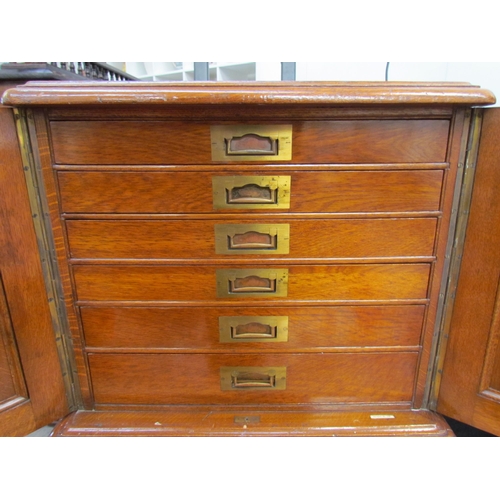 7508 - An early 20th Century honey oak collector’s chest / cutlery canteen, the twin panelled doors opening... 