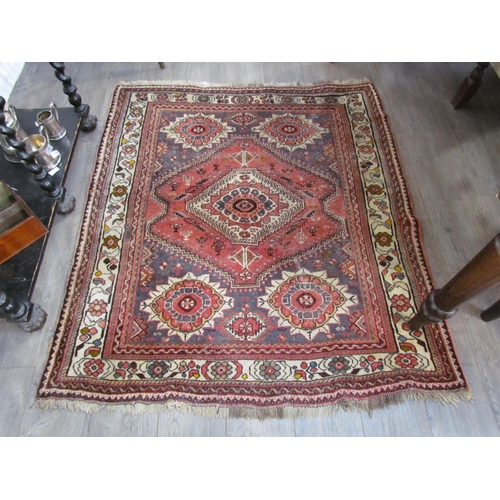 7643 - A Middle Eastern wool rug, central lozenge, dark pink ground, multiple borders, 143cm x 128cm