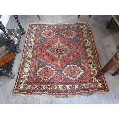 7643 - A Middle Eastern wool rug, central lozenge, dark pink ground, multiple borders, 143cm x 128cm