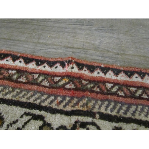 7643 - A Middle Eastern wool rug, central lozenge, dark pink ground, multiple borders, 143cm x 128cm