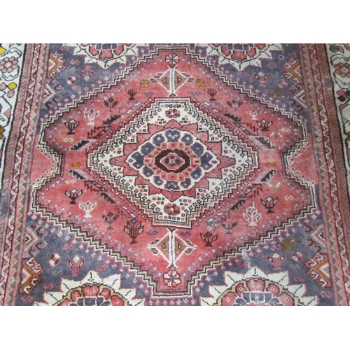 7643 - A Middle Eastern wool rug, central lozenge, dark pink ground, multiple borders, 143cm x 128cm