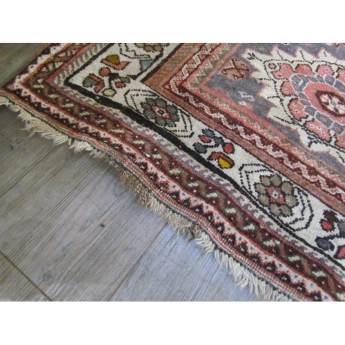 7643 - A Middle Eastern wool rug, central lozenge, dark pink ground, multiple borders, 143cm x 128cm