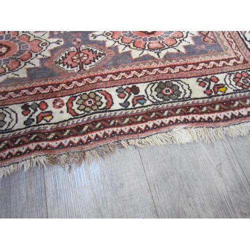 7643 - A Middle Eastern wool rug, central lozenge, dark pink ground, multiple borders, 143cm x 128cm