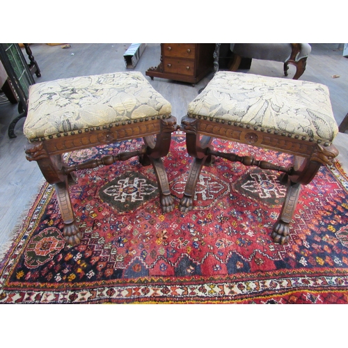 7757 - A pair of Victorian Gothic style oak stools, mythical creature mounts to stretcher base and lions cl... 