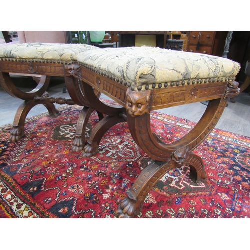 7757 - A pair of Victorian Gothic style oak stools, mythical creature mounts to stretcher base and lions cl... 