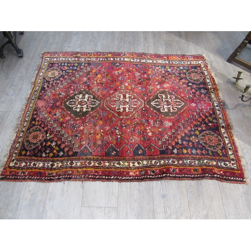 7758 - A Persian silk and wool hand knotted rug, three central guls, red ground, multiple borders, 145cm x ... 