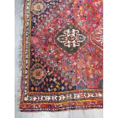 7758 - A Persian silk and wool hand knotted rug, three central guls, red ground, multiple borders, 145cm x ... 