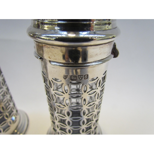 7414 - A pair of Haseler Bros silver openwork bayonet topped pierced sugar castors with clear glass liners,... 