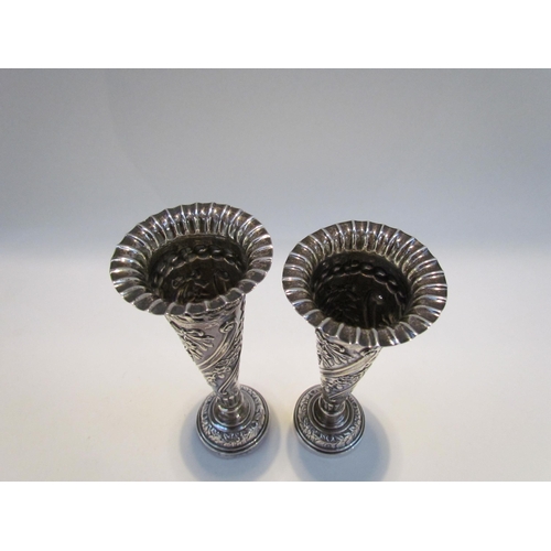 7428 - A near pair of silver embossed bud vases, 11g total